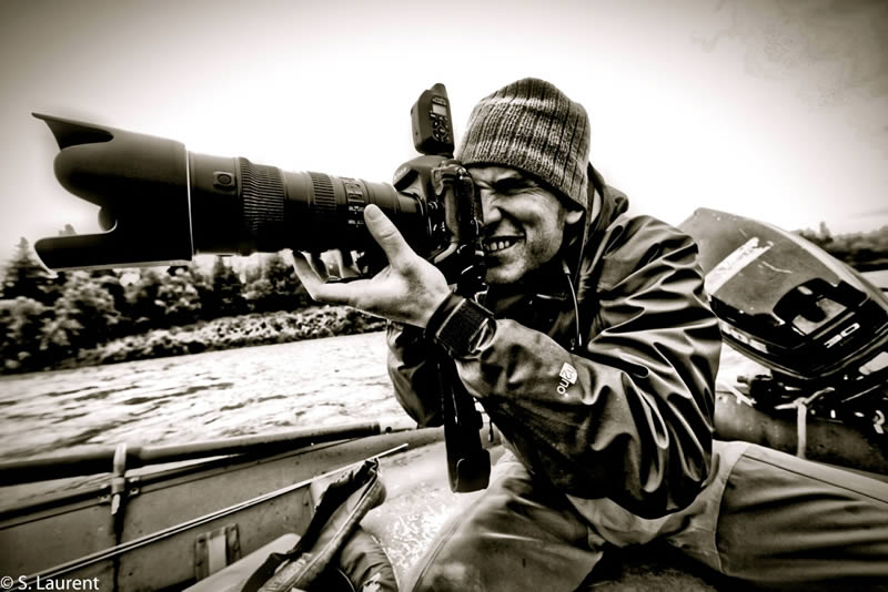 A man holding a camera in a boat.