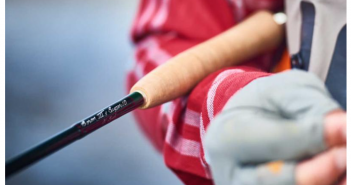 A close up of a person holding a fly rod.