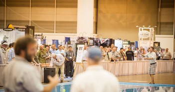 A crowd of people watching a man play a game of frisbee.