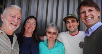 A group of people posing for a selfie in front of a building.