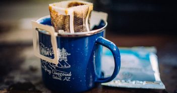 A blue mug with a bag of coffee in it.