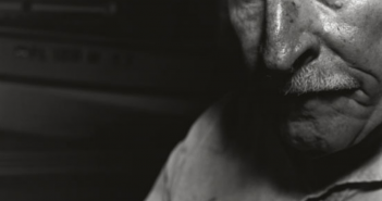 A black and white photo of an old man with a mustache.