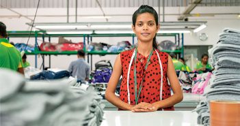 A woman standing at a table in a factory.