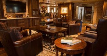 A living room with leather furniture and brick walls.