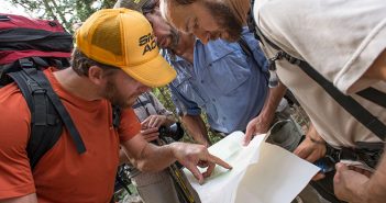 A group of hikers looking at a map.