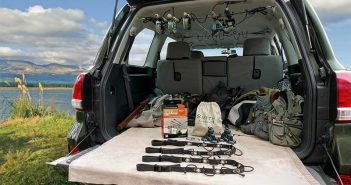 The back of a suv with fishing gear in it.