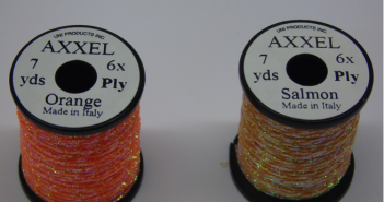 Two spools of orange and salmon colored thread.