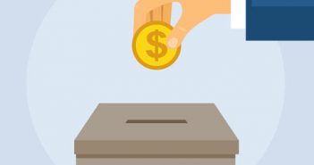 A hand putting a coin into a donation box.