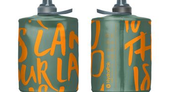 A green bottle with orange writing on it.