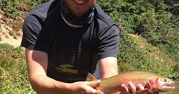 A man holding a rainbow trout.