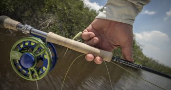 A person holding a fly fishing rod and reel.