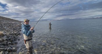 A man is standing in the water with a fly rod.