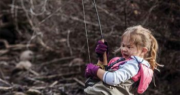 The cover of trout magazine with a young girl fishing.