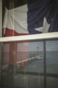 A texas flag hanging from a window.