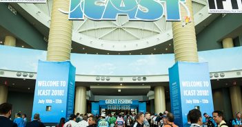 A group of people walking through a convention center.