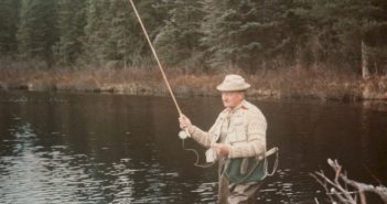 A man holding a fly rod in a body of water.