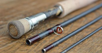 A pair of fly rods on a wooden table.