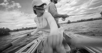 A man and woman in a canoe on a river.