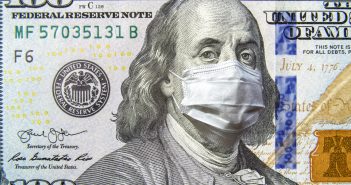 A one hundred dollar bill with a medical mask on it.