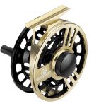 A gold and black fly reel on a white background.