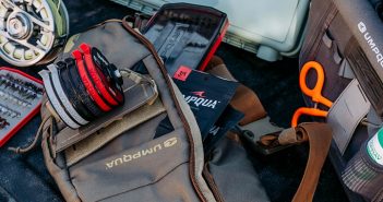 The contents of a fishing bag are laid out in the back of a truck.