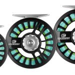 Three fly reels on a white background.
