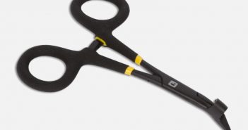 A pair of black and yellow scissors on a white surface.