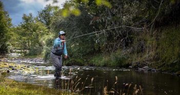 A man is fly fishing in a river.