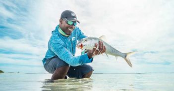 A man holding a fish in the water.