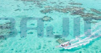 An aerial view of a boat in the ocean with the word baju written on it.