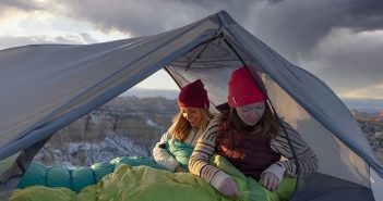 Two women sleeping in a tent.