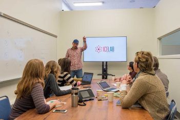 A group of people sitting around a table in a conference room.