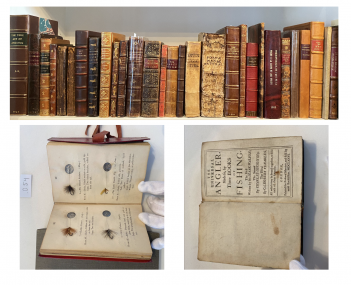 A collection of old books on a shelf with a hand holding a book.