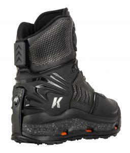 A pair of black ski boots with orange soles.