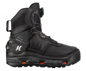 A black snowboard boot with orange soles.