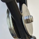 A close up of a bicycle handlebar with a nut on it.