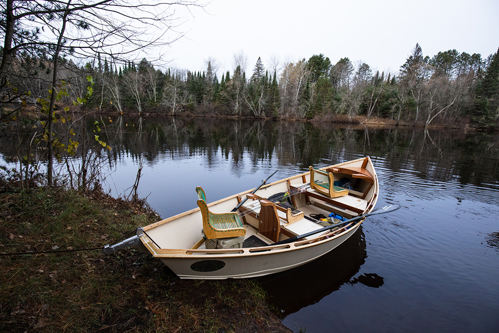 A small boat sitting on the shore of a body of water.