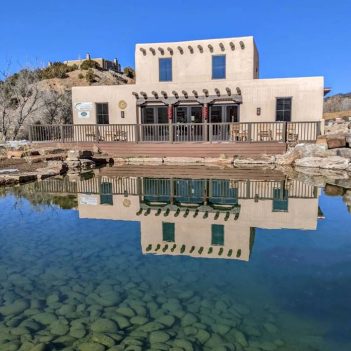 A building with a pond in front of it.