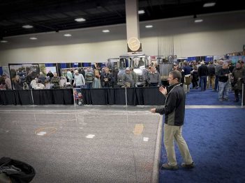A man standing in front of a crowd at a convention.