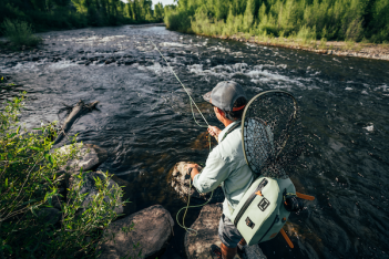 A man is fly fishing in a river.