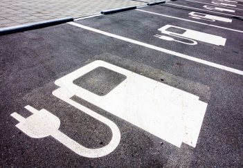 A parking lot with electric car chargers painted on it.