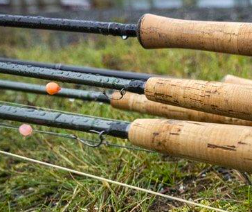 A group of fly rods laying on the ground.