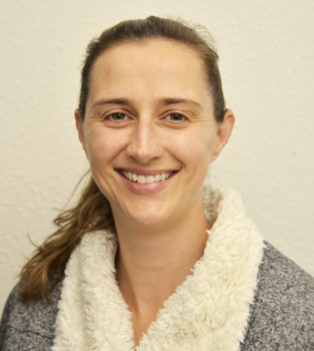 A smiling woman wearing a robe.