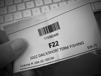 A person holding up a fishing ticket that says f2.