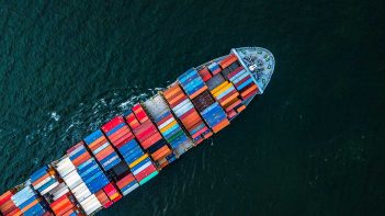 An aerial view of a container ship in the ocean.