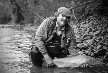 A man holding a fish in a river.