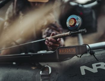 A man is holding a fishing rod on a boat.