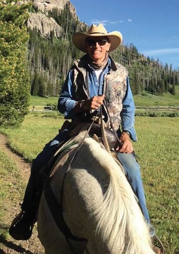 A man in a cowboy hat riding a horse.