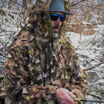 A man wearing a camouflage jacket holding a fishing rod.