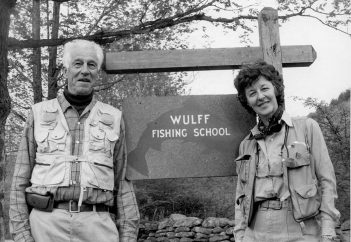 Two people standing in front of a sign that says wulff fishing school.
